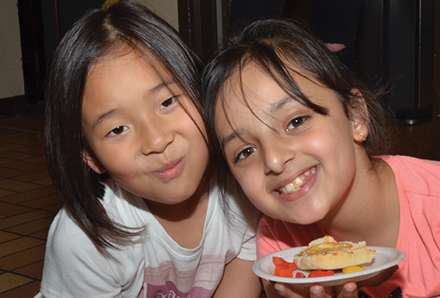 two young girls with a plate of snacks